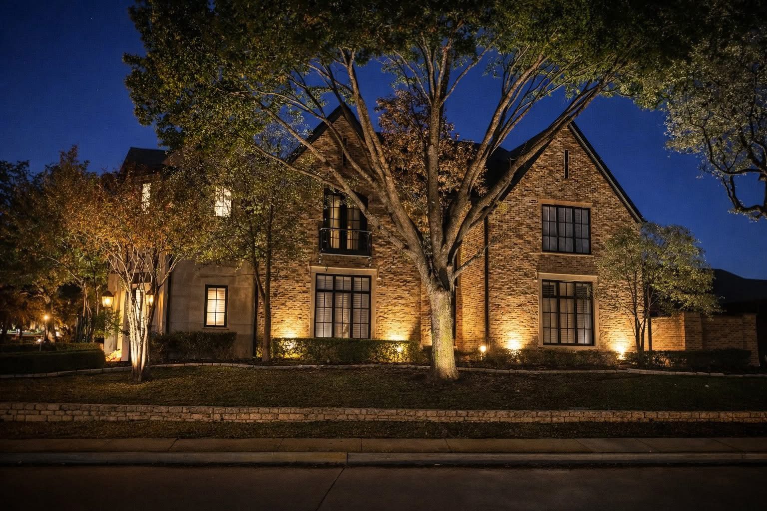 Architectural lighting on brick walls, with tree uplighting
