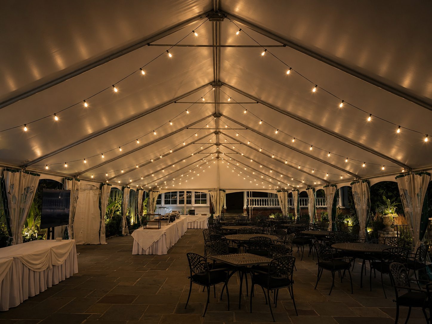 Event tent with warm string lights over tables