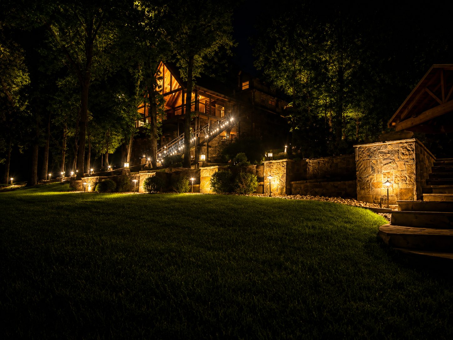 Pavilion with warm string lights beside a paved court