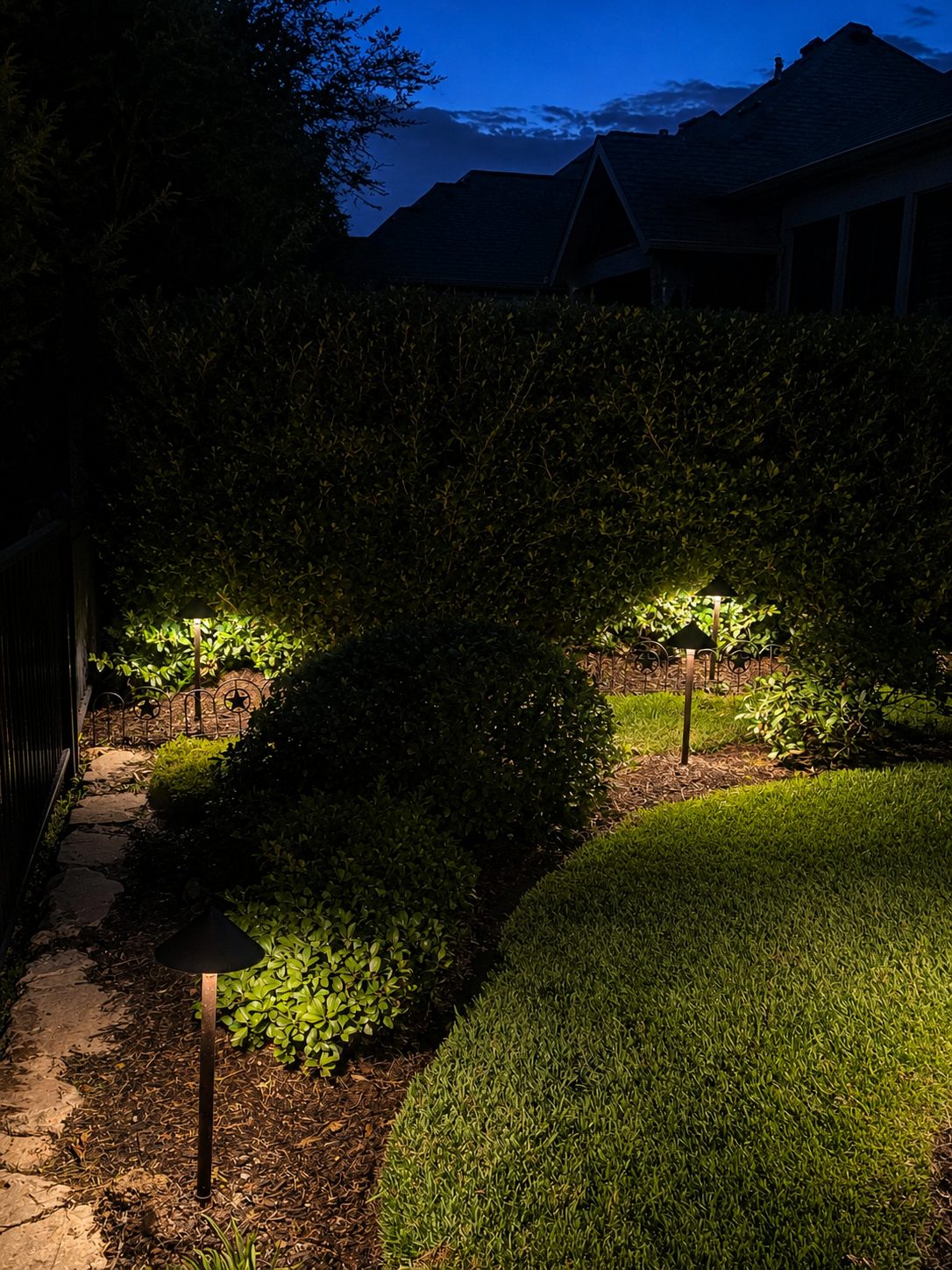Path lights on a hedge and shrubs