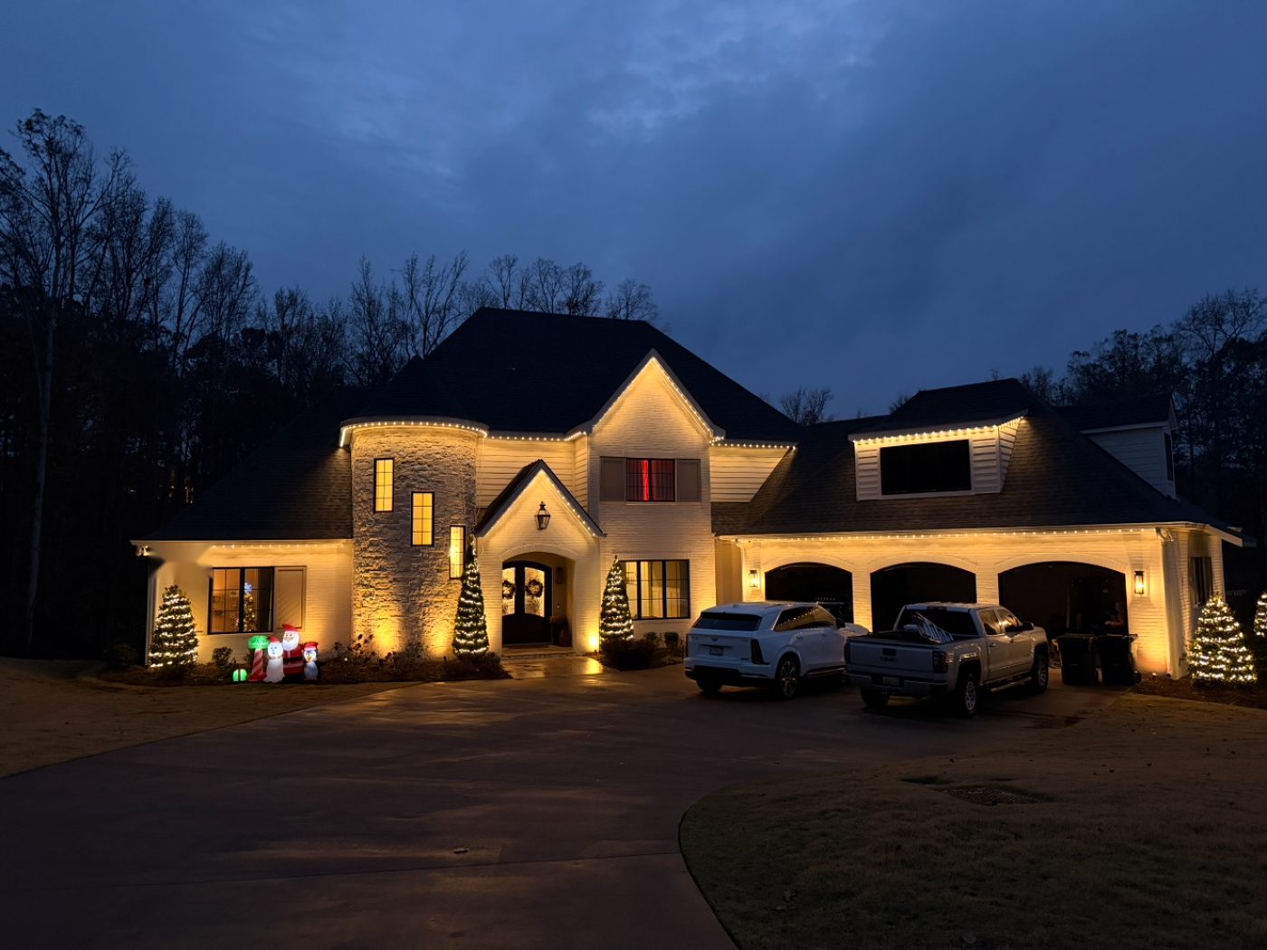 Permanent lighting in warm white along the roofline of a light-colored home