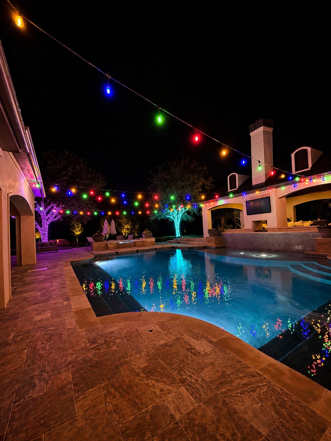 Wedding and party rentals: multicolor string lights over a pool