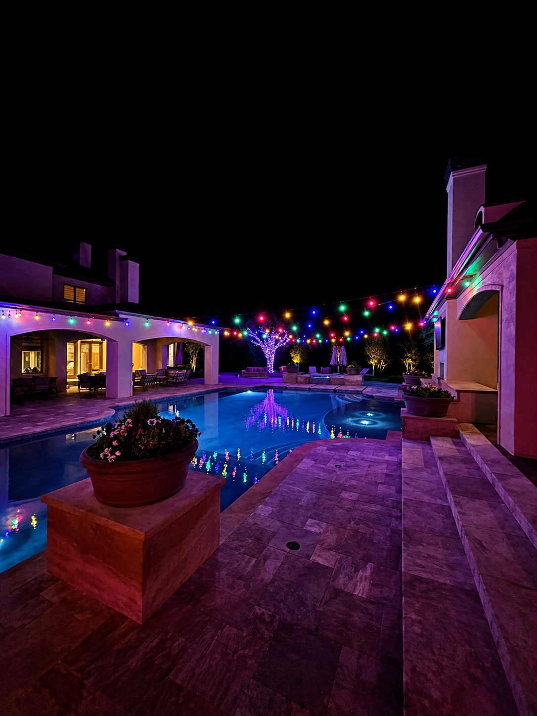 Wedding and party rentals: a wider view of multicolor string lights over a pool