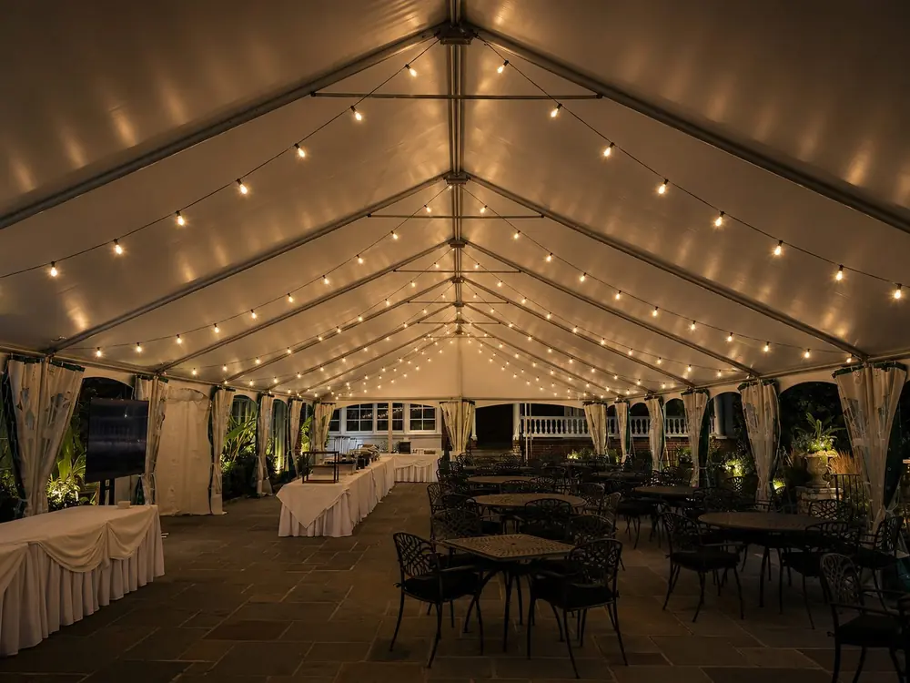 Wedding and party rentals: a tent with warm string lights